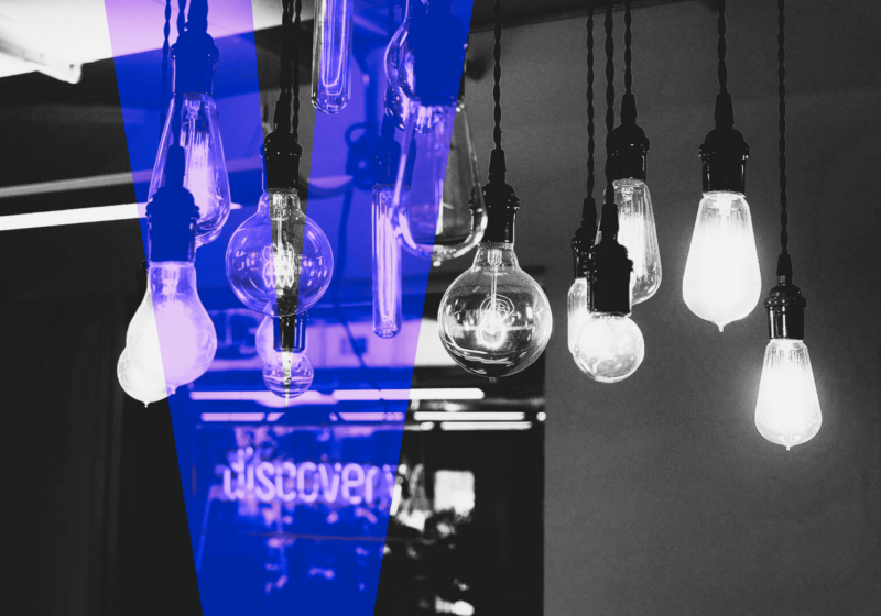Mindgrub Ventures lightbulbs dangling over a neon sign of the word discovery